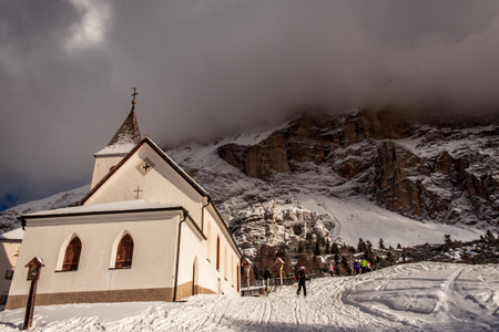 An old church on the top of the mountain in italian alps during winter seasonの写真素材