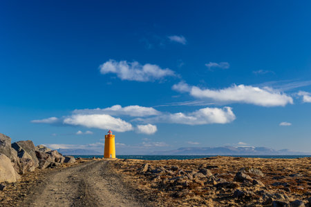 Lighthouse on the coast of iceland in a cold march dayの写真素材