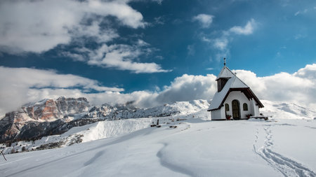An old church on the top of the mountain in Italian Alps during winter seasonの写真素材
