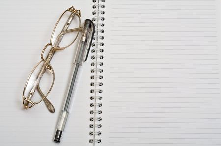 Spectacles with ball pen on open diaryの写真素材