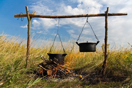 Boiling water in pots above the fire の写真素材
