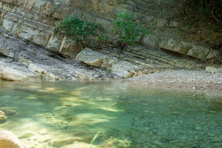Mountain river on the background of the layered surface of the earth covered with plantsの写真素材