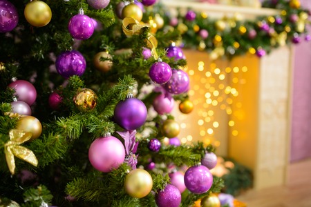 Christmas tree decorated in purple toy. Christmas background with presents in the interiorの写真素材