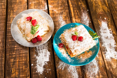 Mille-feuille of puff pastry with raspberries on a wooden Boardの写真素材