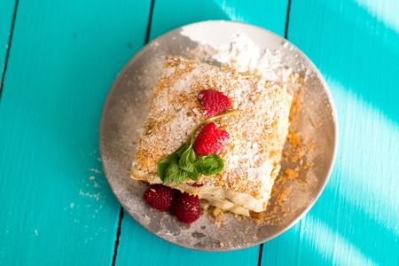 Mille-feuille of puff pastry with raspberries on a wooden Board cyanの写真素材