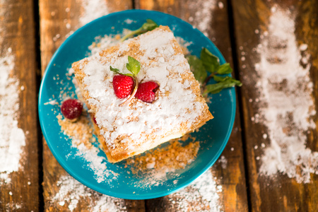 Mille-feuille of puff pastry with raspberries on a wooden Boardの写真素材