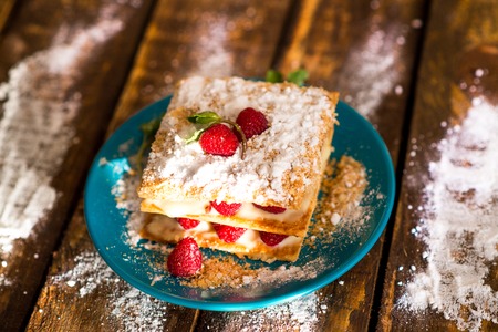 Mille-feuille of puff pastry with raspberries on a wooden Boardの写真素材