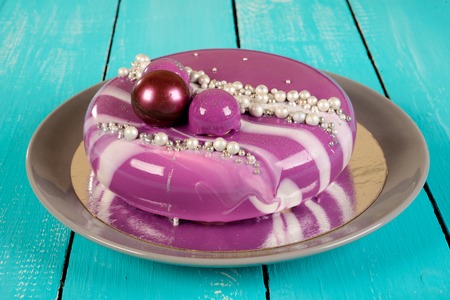 purple mousse cake with mirror glaze with blackberries, blueberries and coconut fillingの写真素材