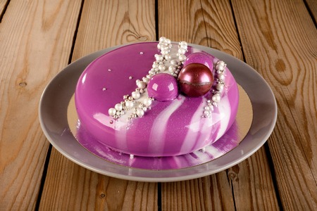 purple mousse cake with mirror glaze with blackberries, blueberries and coconut fillingの写真素材
