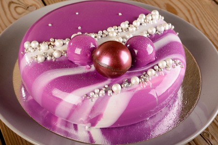 purple mousse cake with mirror glaze with blackberries, blueberries and coconut fillingの写真素材