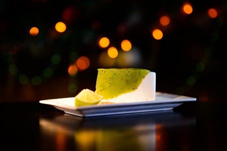 Delicious KIWI cake dessert on a plate on dark tableの写真素材