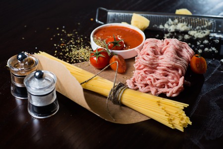 Food ingredients for Italian spaghetti, tomatoes, ground beef, black backgroundの写真素材