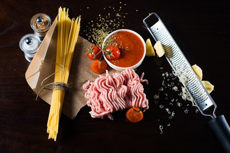 Food ingredients for Italian spaghetti, tomatoes, ground beef, black backgroundの写真素材