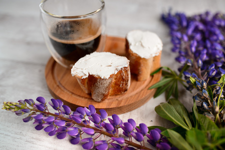 coffee mug served with bruschetta on a wooden Board and lupins flowers on the tableの写真素材