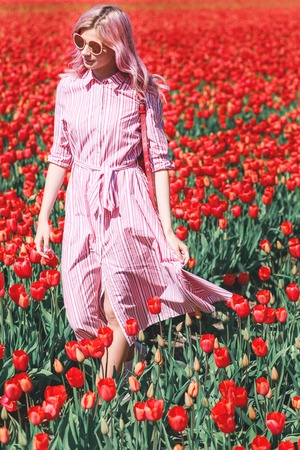 Smiling teenage girl walks through tulip field.Hollandの写真素材