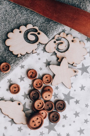 Wooden toy silhouette lamb, star, month, mountain, cactus, Christmas tree on grey background. near wooden buttonsの写真素材