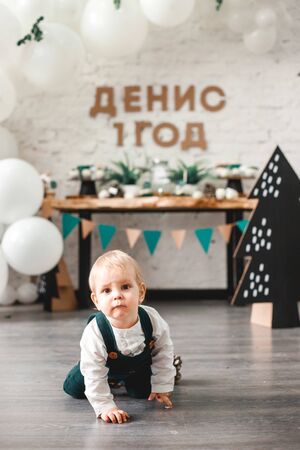 celebrating the first birthday of a little boy in a beautiful interior decorated with balloonsの写真素材
