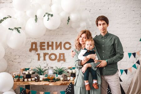 Parents hold a small son in their arms. The concept of a happy family, motherhood and parenthood, care.の写真素材