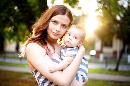 A mother and her child are enjoying early spring, the background is illuminated by the sunの写真素材