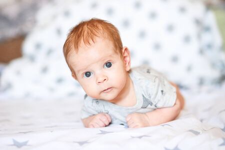 Cute happy 7 month old boy is lying in his crib