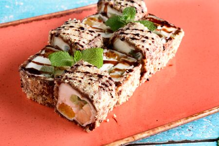 Dessert Maki sushi roll with various fruits and cream cheese inside. Served with chocolate sauceの写真素材