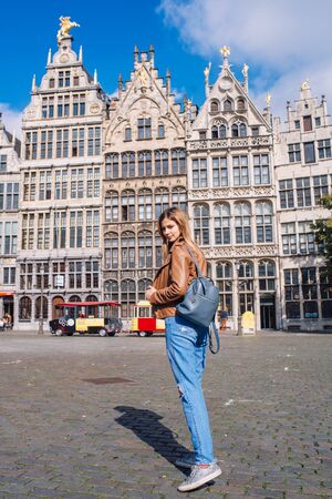Young woman tourist walking on the Great Market square during the morning in Antwerpen, Belgiumの写真素材