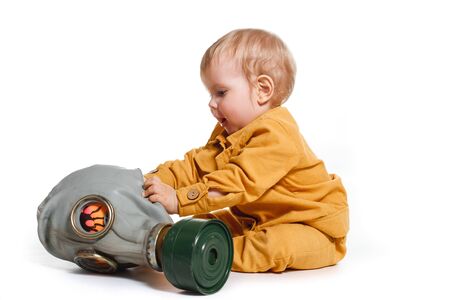 a small boy in a yellow suit with a gas mask, isolated on a white backgroundの写真素材