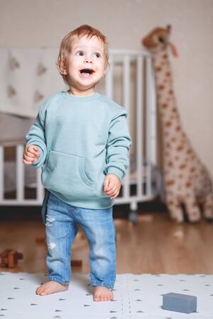 a boy is playing in his room in a Mint colored hooded sweaterの写真素材