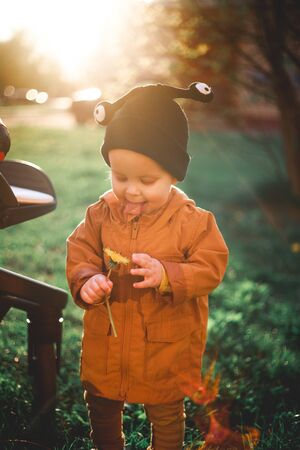 portrait of a one year old boy with a snail wool cap on the background of natureの写真素材