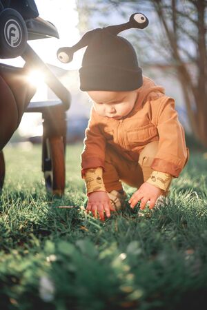 portrait of a one year old boy with a snail wool cap on the background of nature