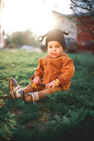 portrait of a one year old boy with a snail wool cap on the background of natureの写真素材