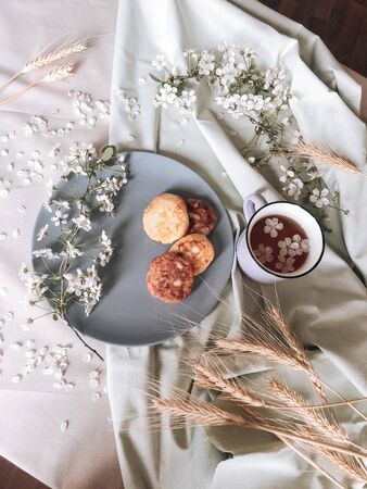 spring healthy Breakfast fried cheesecakes, against a blooming bouquet of white flowers
