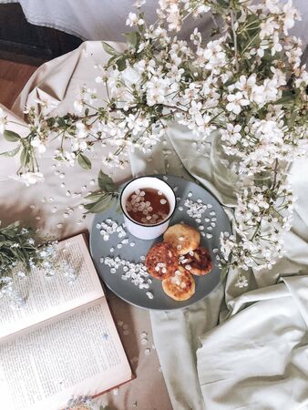 spring healthy Breakfast fried cheesecakes, against a blooming bouquet of white flowersの写真素材