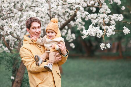 father and son in a lush garden next to Apple trees in spring