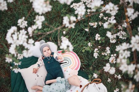 A lovely sweet boy under a blooming Apple tree on a Sunny spring day.の写真素材