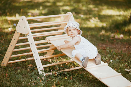 Kid playing sport in children's slide on the sports complex. 1.5 year old toddler baby climbing up the gymnastic stairs. Early childhood development. Lifestyle activityの写真素材