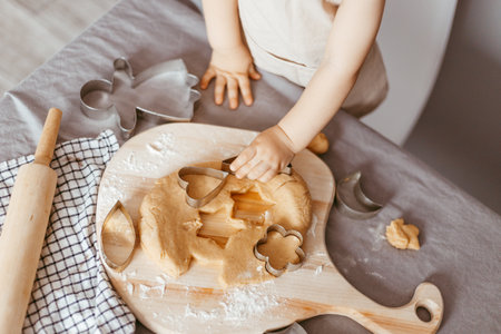 Portrait of a little cook kneading dough in an apron and a chef's hat. Cooking children's lifestyle conceptの写真素材
