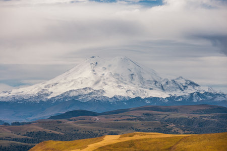 Big mountain Elbrus against the blue sky. View from a large plateau and steep cliffs. Russiaの写真素材