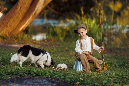 Kid with fishing rod. Child fishing at autumn lakeの写真素材