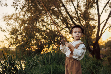 Child fishing at autumn lakeの写真素材