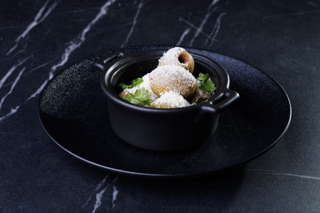 Gourmet Olive Appetizer In Black Ceramic Pot With Parsley Garnish On Dark Plateの写真素材