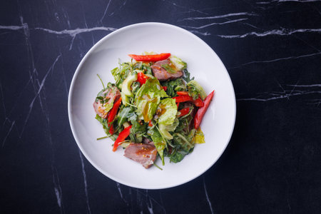 Elegant Fresh Garden Salad With Steak Slices and Crunchy Veggies in White Bowlの写真素材