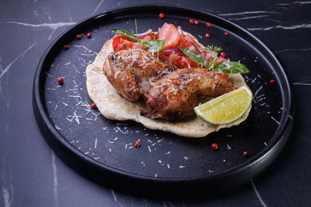 Roasted Chicken on Flatbread With Tomato Salad, Lime Wedge, and Fresh Herbsの写真素材