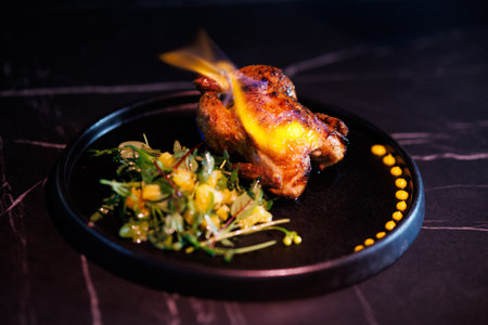 Roasted Chicken Leg Plate with Fresh Greens and Sauces on Dark Marble Table for Dinnerの写真素材
