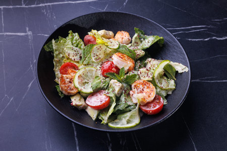 Gourmet Shrimp And Citrus Salad On Black Plate For Elegant Dinner Table Settingの写真素材