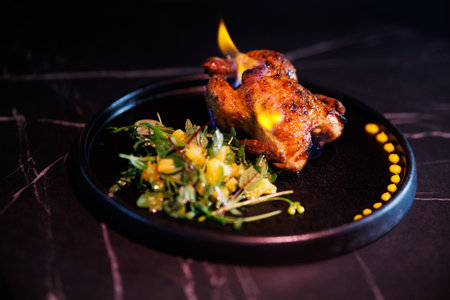 Roasted Chicken Leg Plate with Fresh Greens and Sauces on Dark Marble Table for Dinnerの写真素材