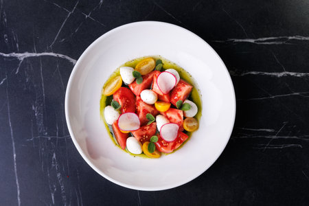 Colorful Tomato Burrata Salad With Radish, Olives, And Fresh Herbs On White Plate