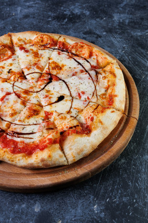 Cheesy Pizza Sliced On A Wooden Board With Tomato Sauce And Crispy Crust