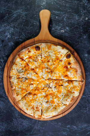 Cheese Pizza with Chicken and Melted Cheese on a Wooden Boardの写真素材