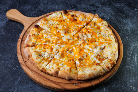 Cheese Pizza with Chicken and Melted Cheese on a Wooden Boardの写真素材